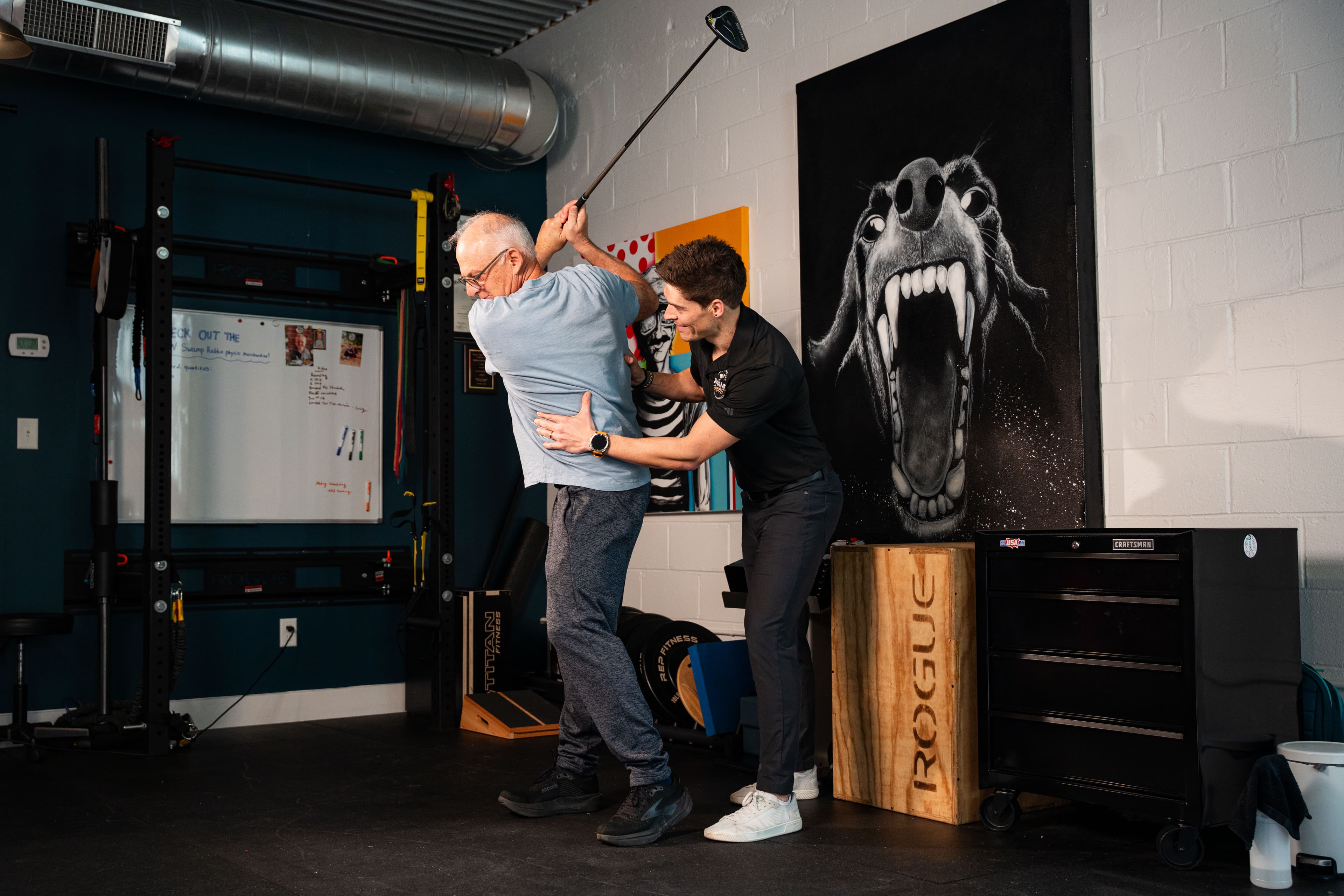 Physical therapist assessing a patient's golf swing mechanics during a return-to-sport rehabilitation session at Swamp Rabbit Physiotherapy in Greenville, SC