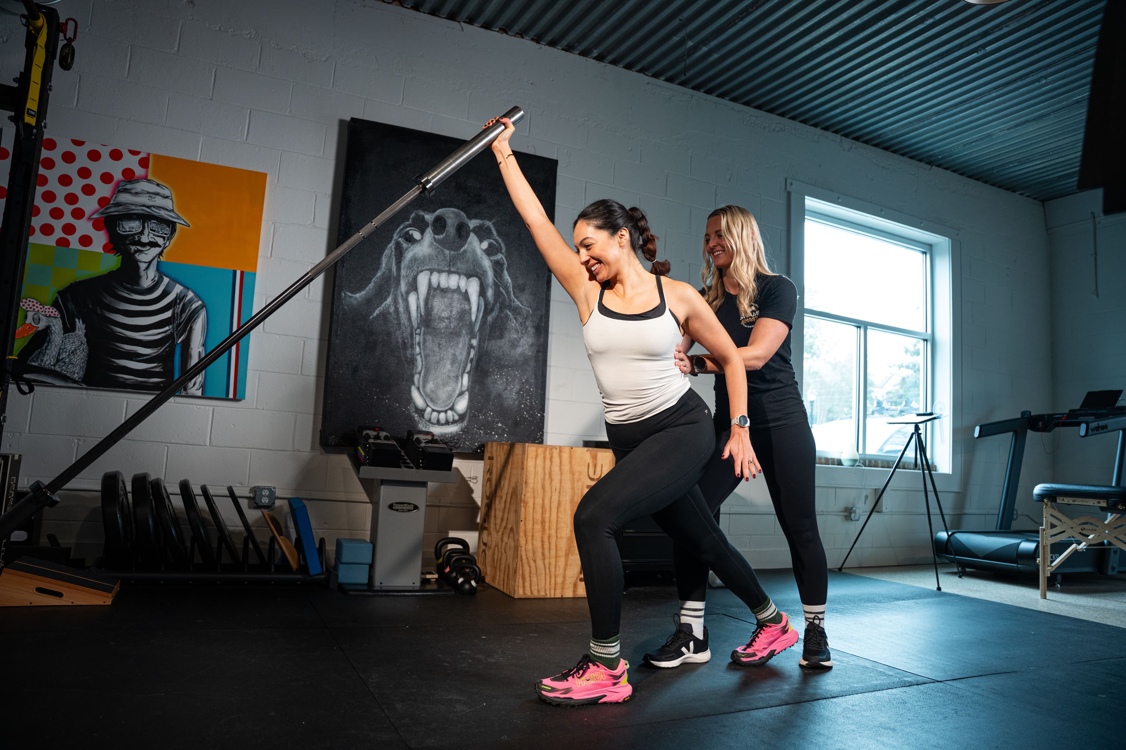 Physical therapist guiding a patient through an overhead barbell mobility drill during CrossFit rehabilitation at Swamp Rabbit Physiotherapy in Greenville, SC